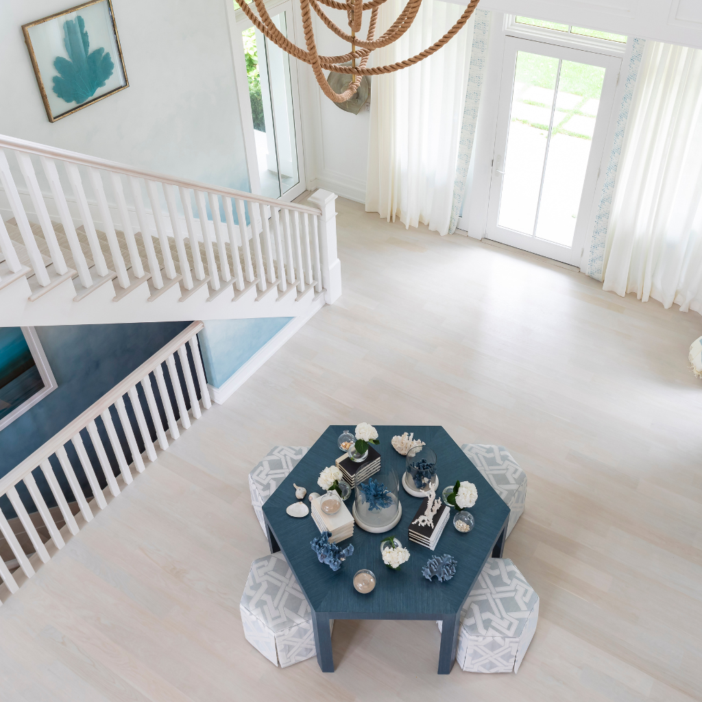 Hexagonal table with decorative items in a bright room with white walls and large windows.