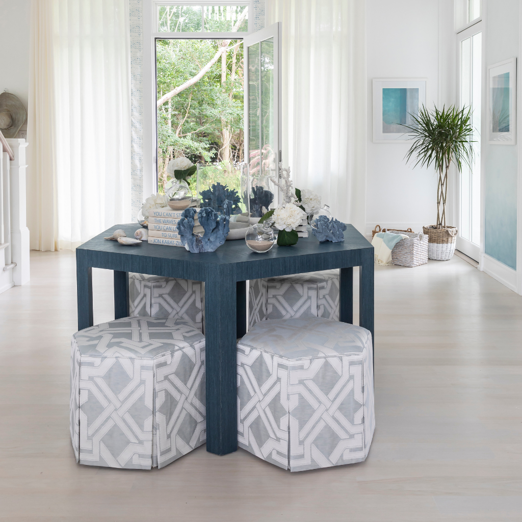 Blue table with decorative items in a bright room with large windows.