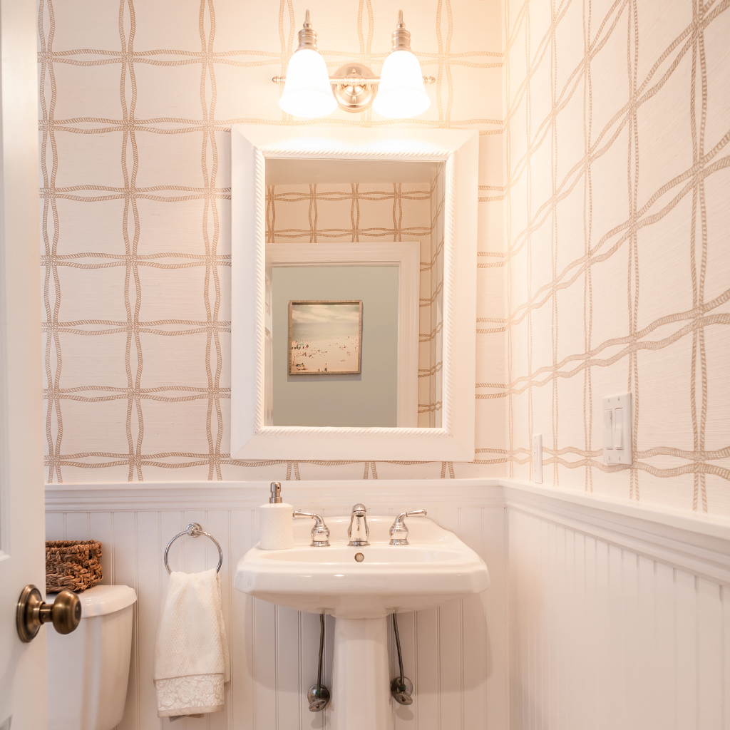 Bathroom with sink, mirror, and decorative wall paper