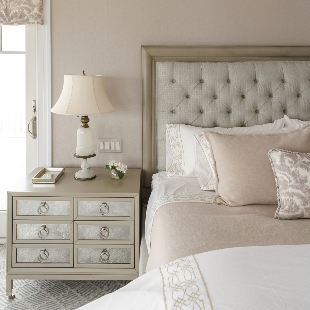 Neatly arranged bedroom with a bed, nightstand, and lamp.