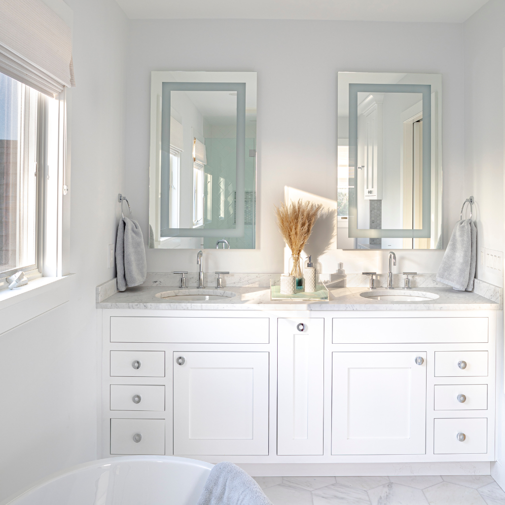 Bathroom with white vanity, mirrors, and decor