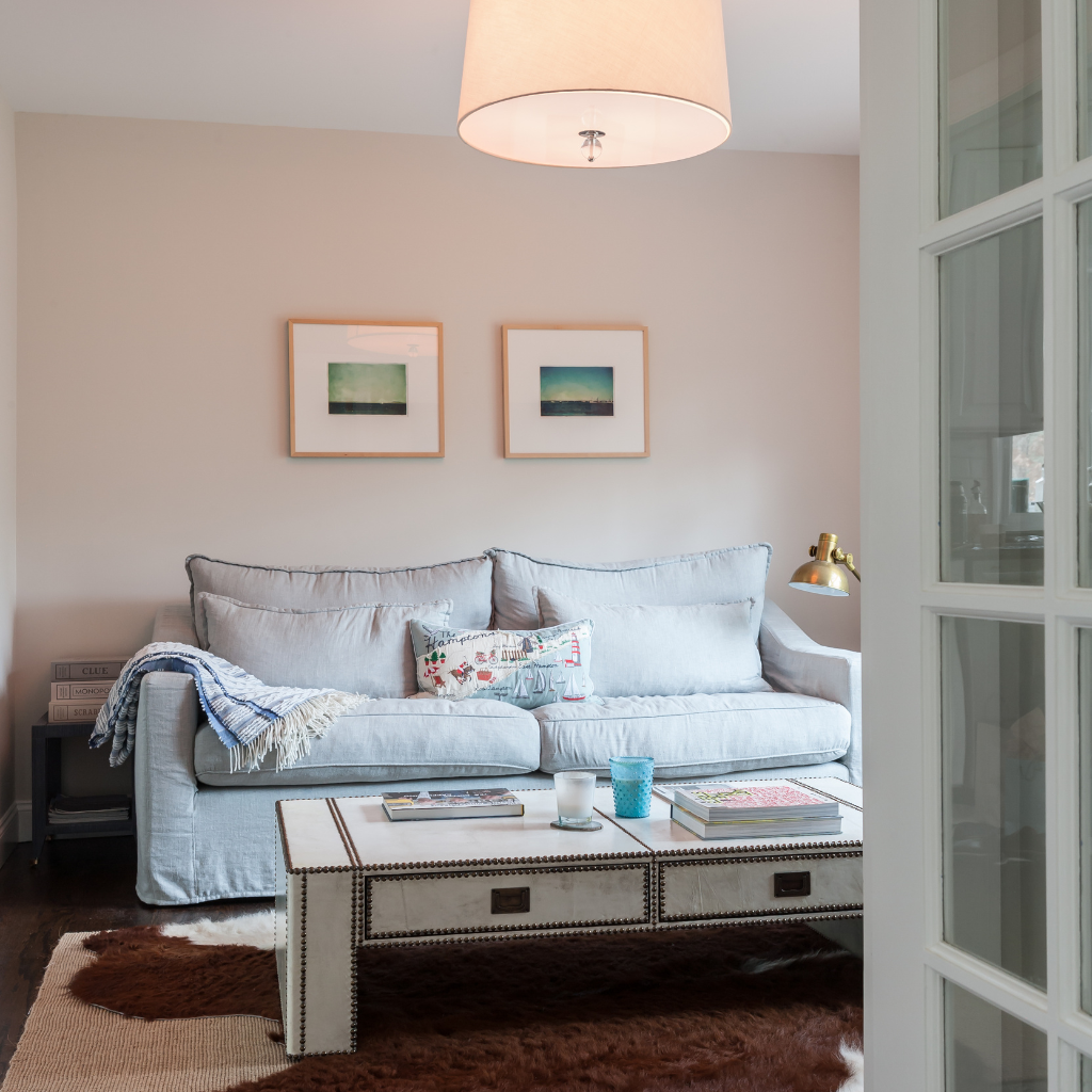 Living room with a gray sofa, coffee table, and framed pictures on the wall.