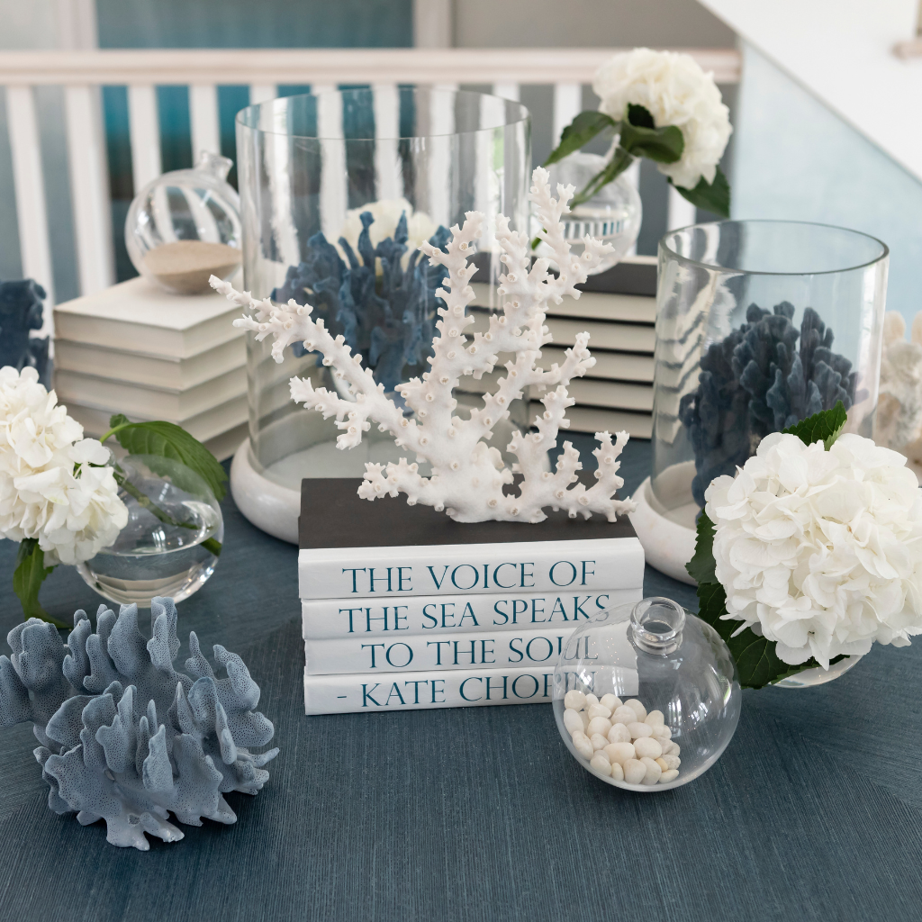 Decorative setup with coral, books, and flowers on a table.