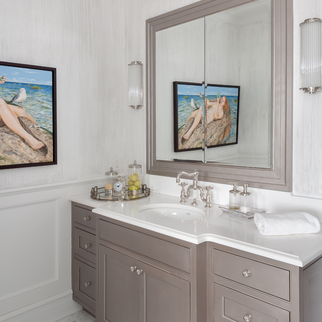 Bathroom with gray vanity, white countertop, and framed artwork on the wall.