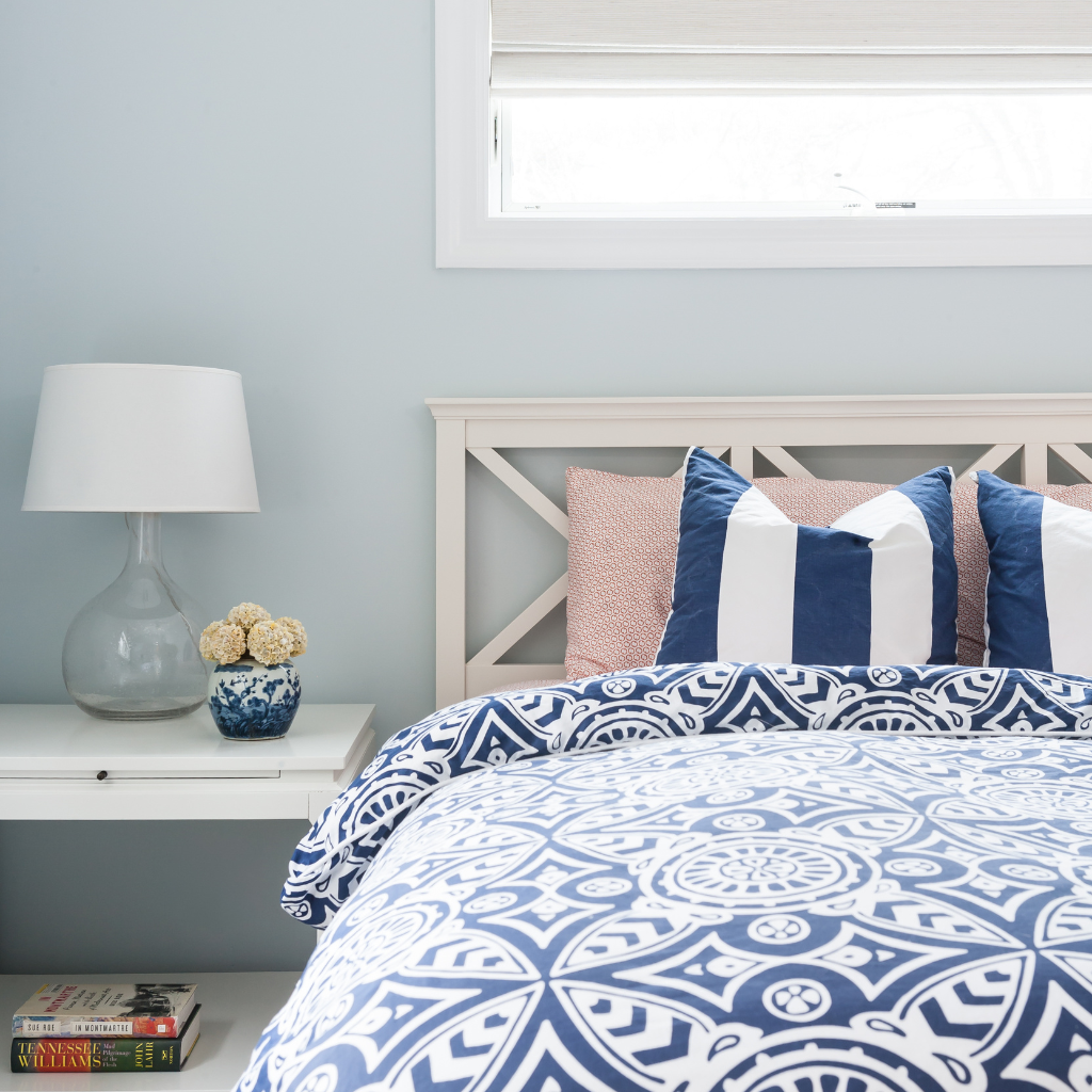 Bedroom with blue and white patterned bedding and pillows.