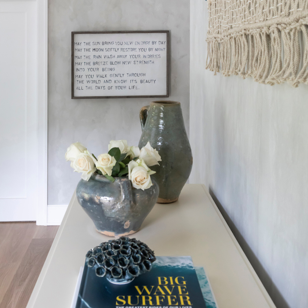 Decorative setup with vases, flowers, and a book on a surface.