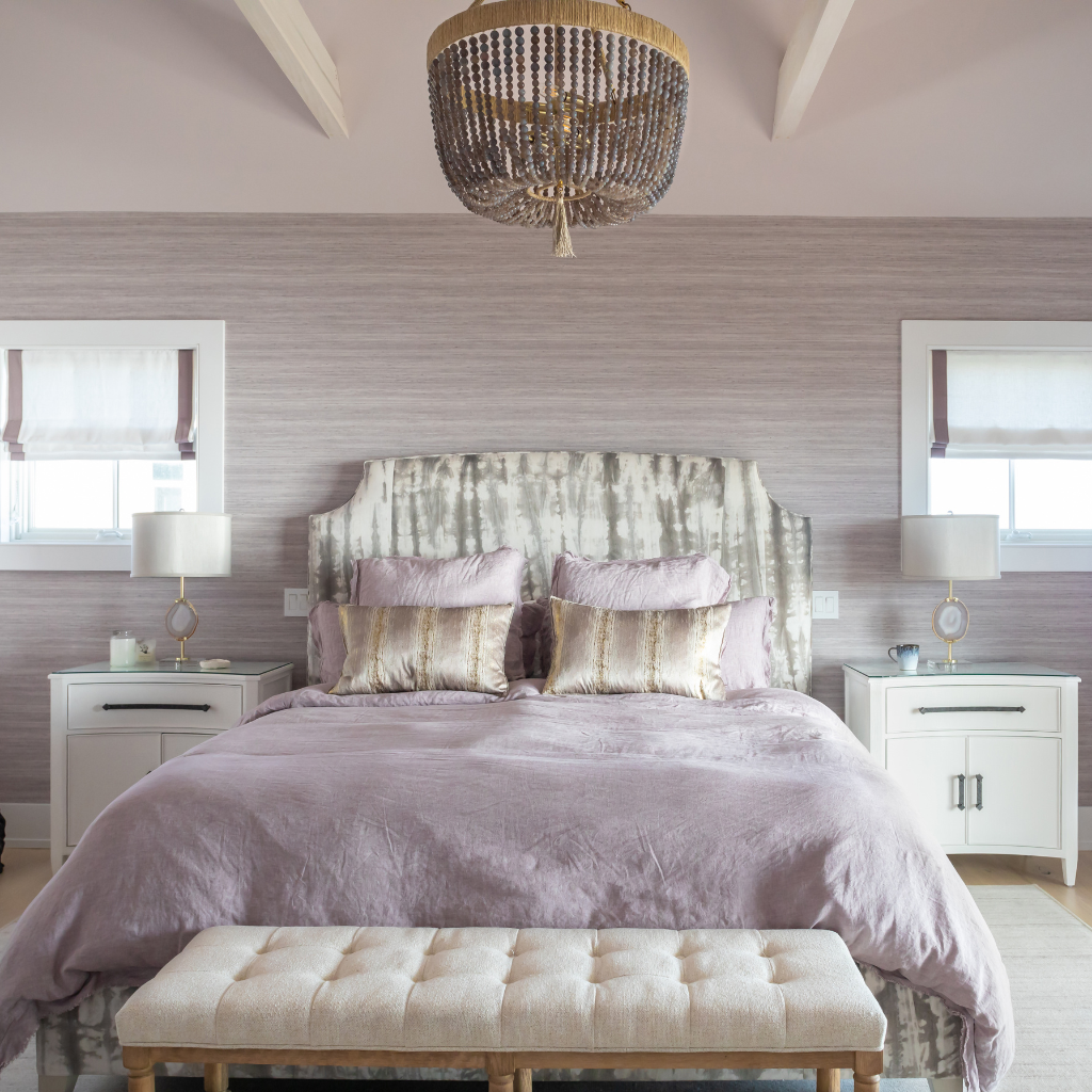 Neatly made bed with decorative pillows in a bedroom setting.