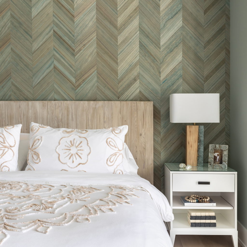 Bedroom with wooden headboard, patterned wallpaper, and nightstand with lamp.