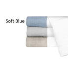 Stack of folded towels in soft blue, gray, and white on a white background