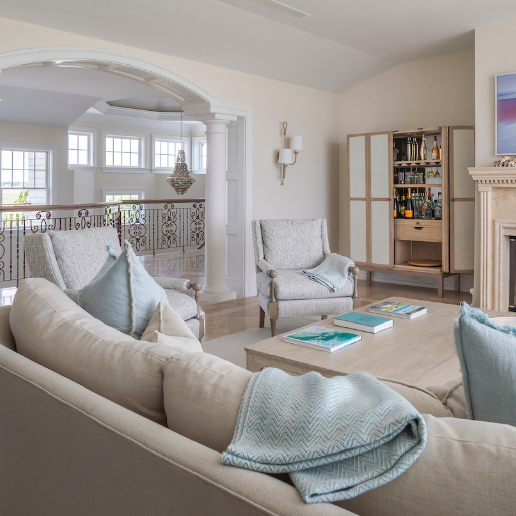 Living room with beige sofa, armchair, and coffee table with decorative items.