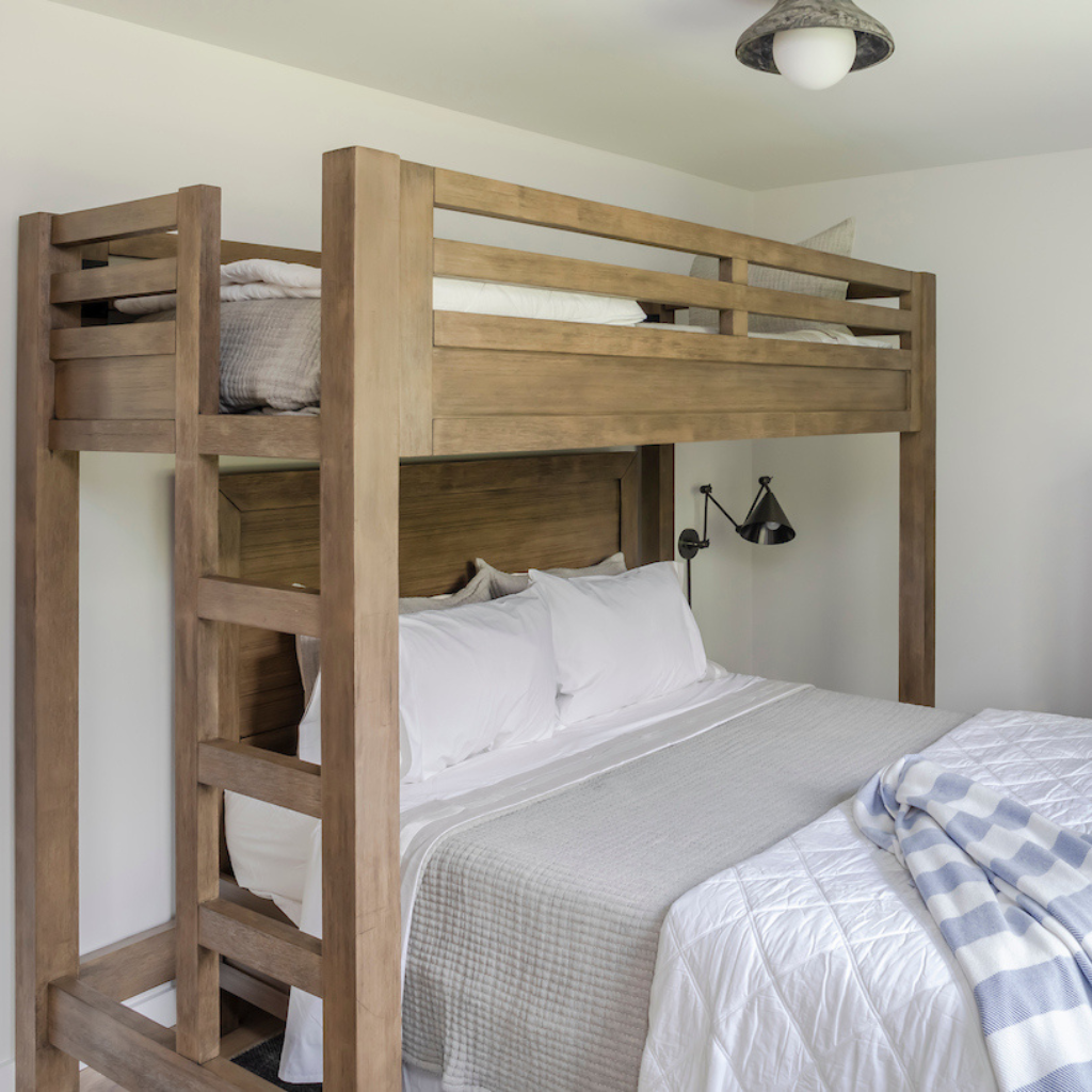 Wooden bunk bed with white bedding in a room setting
