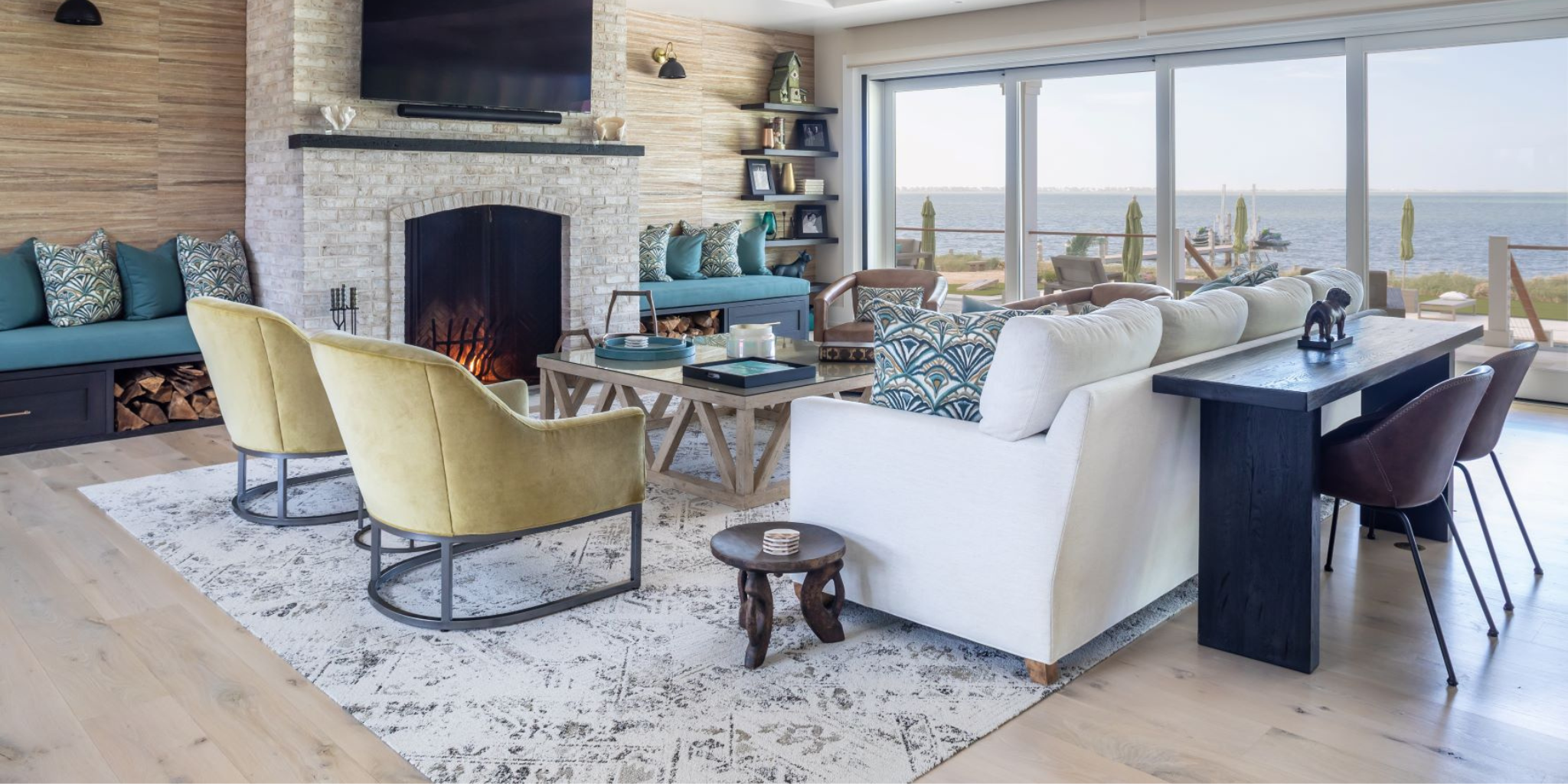 Modern living room with white sofa, yellow chairs, and a fireplace.