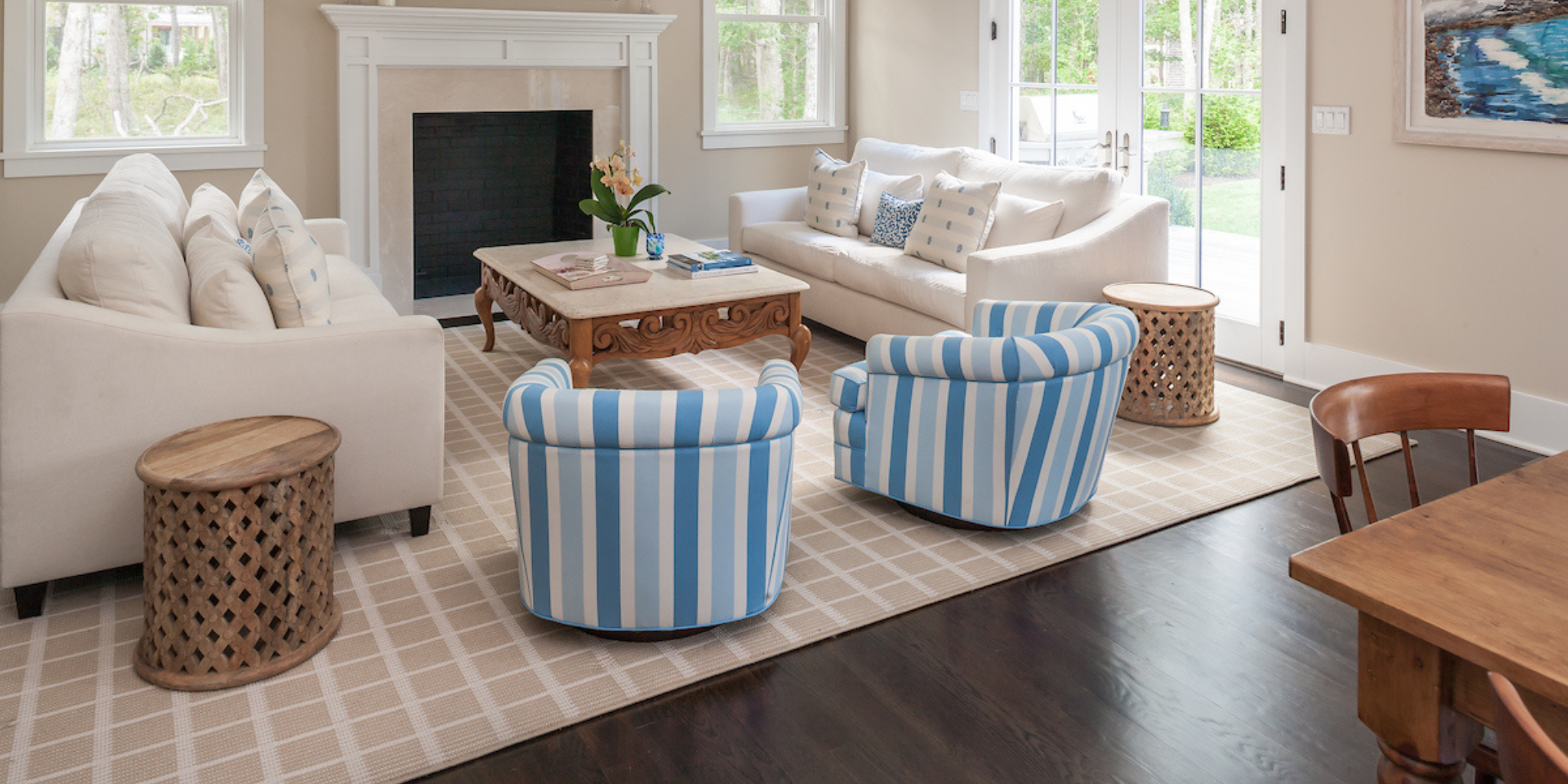Living room with striped armchairs, coffee table, and white sofa.