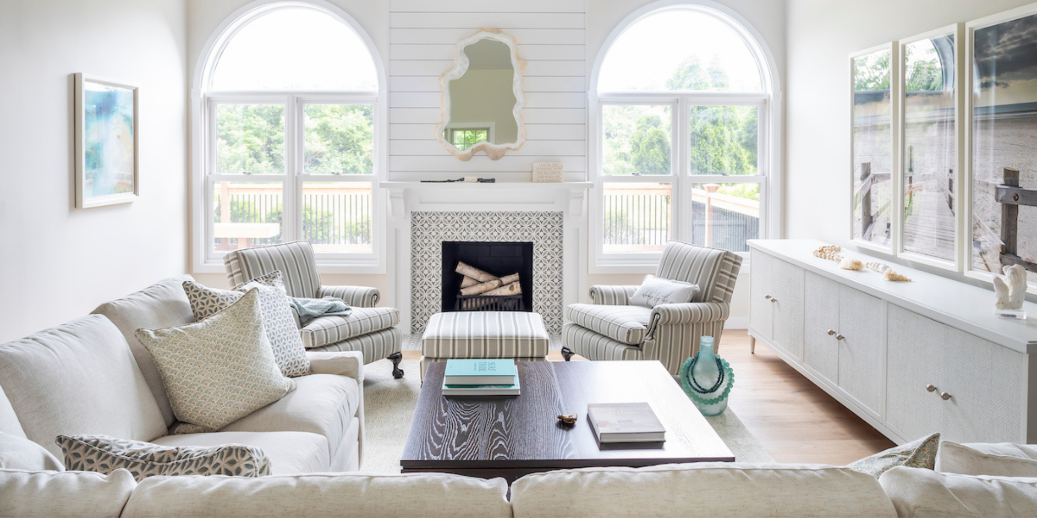 Living room with white walls, large windows, and a fireplace.