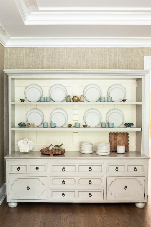 Built-in shelving styled with white dishware and decorative accents.
