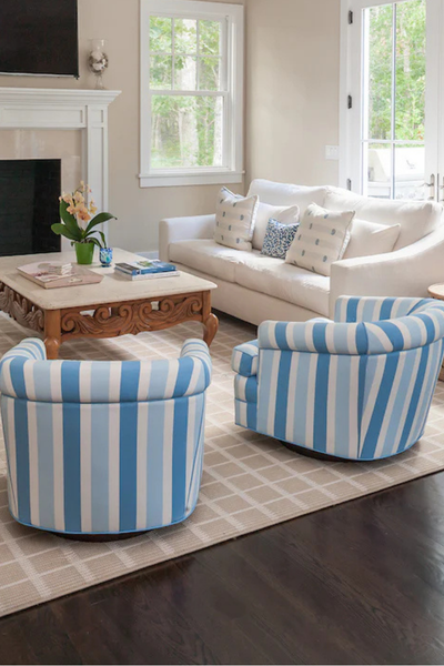 Living room with white sofa, striped blue chairs, and a coffee table.