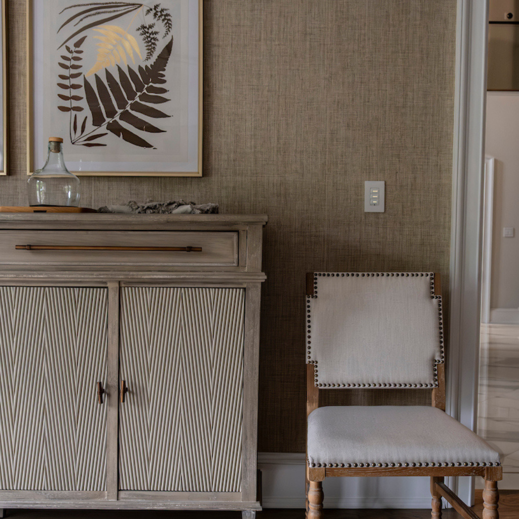 A lovely chair next to a beautiful chest adorned with decor