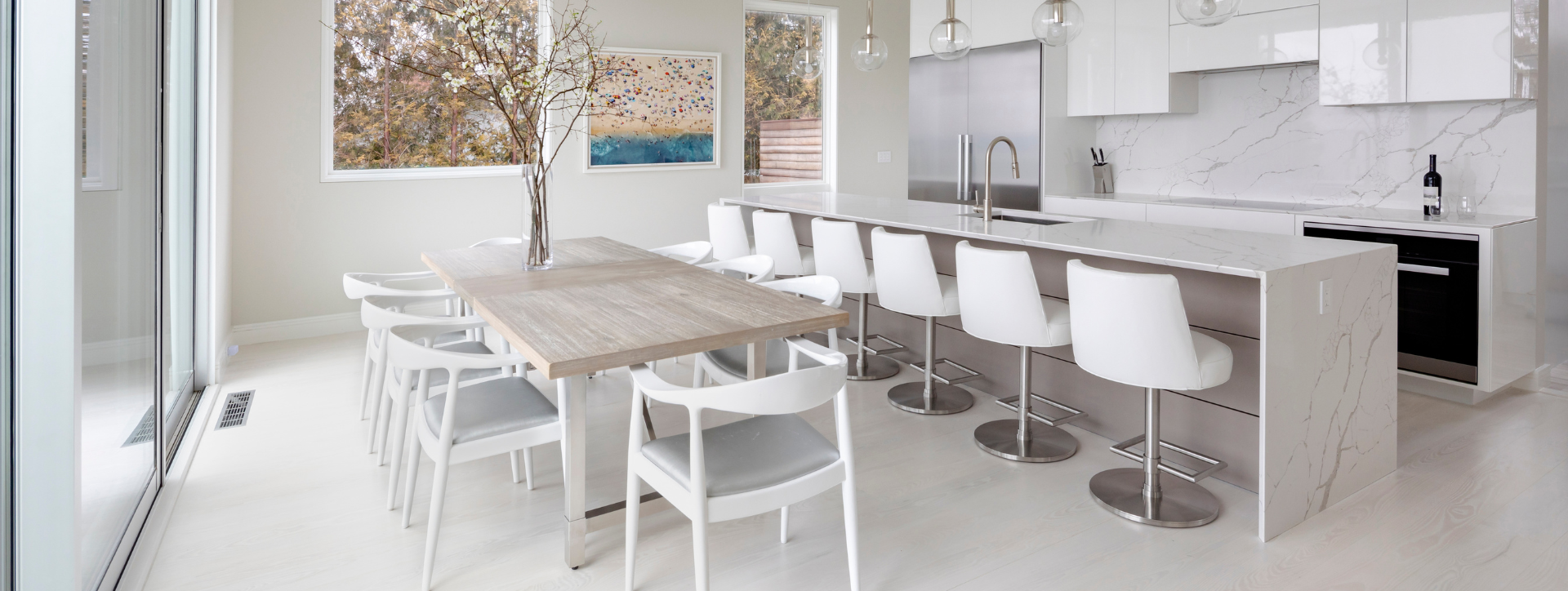 Modern kitchen with a dining table and chairs in a bright, minimalistic setting.