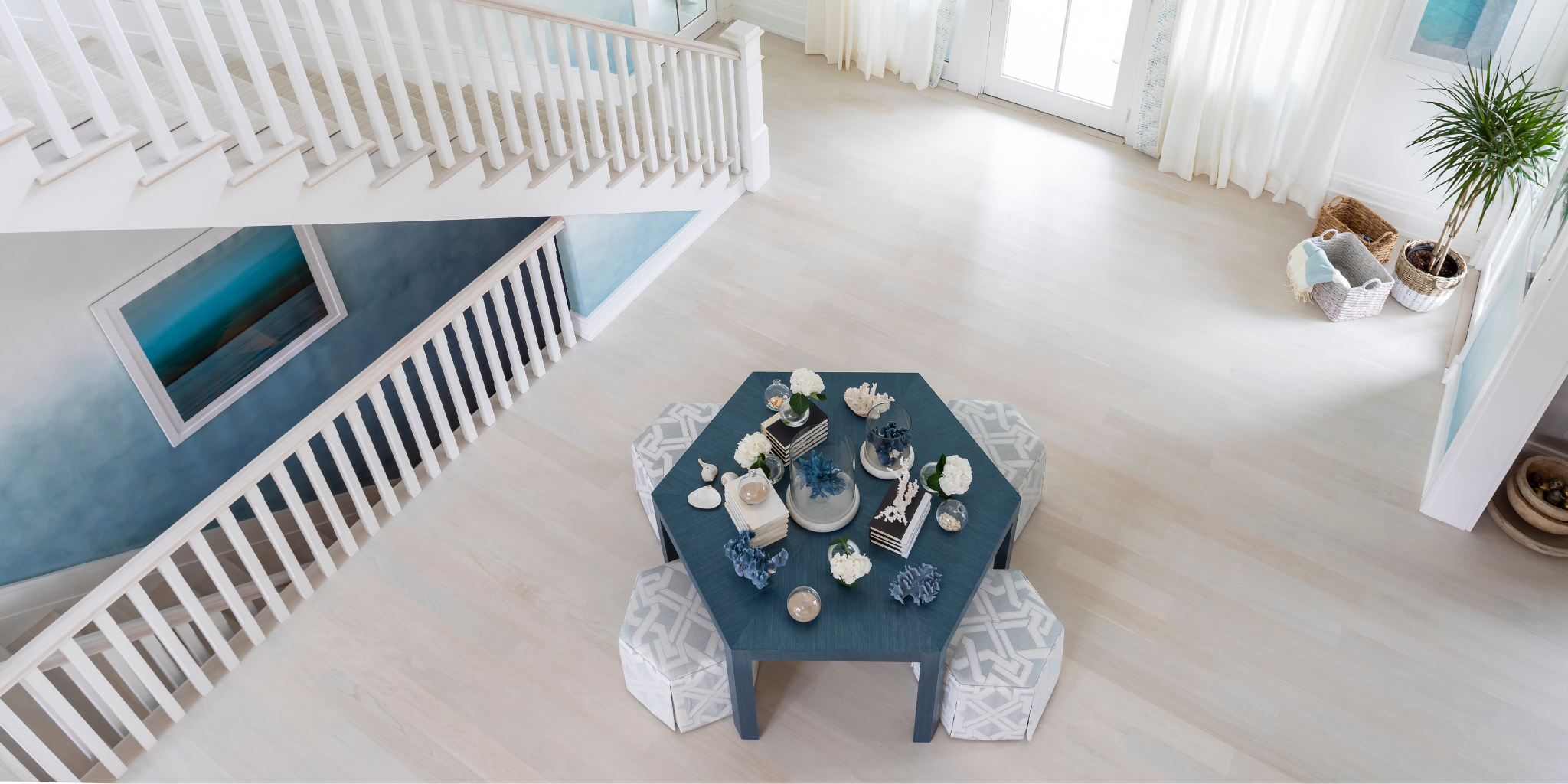 Hexagonal table with decorative items in a bright room with white floors and blue walls.