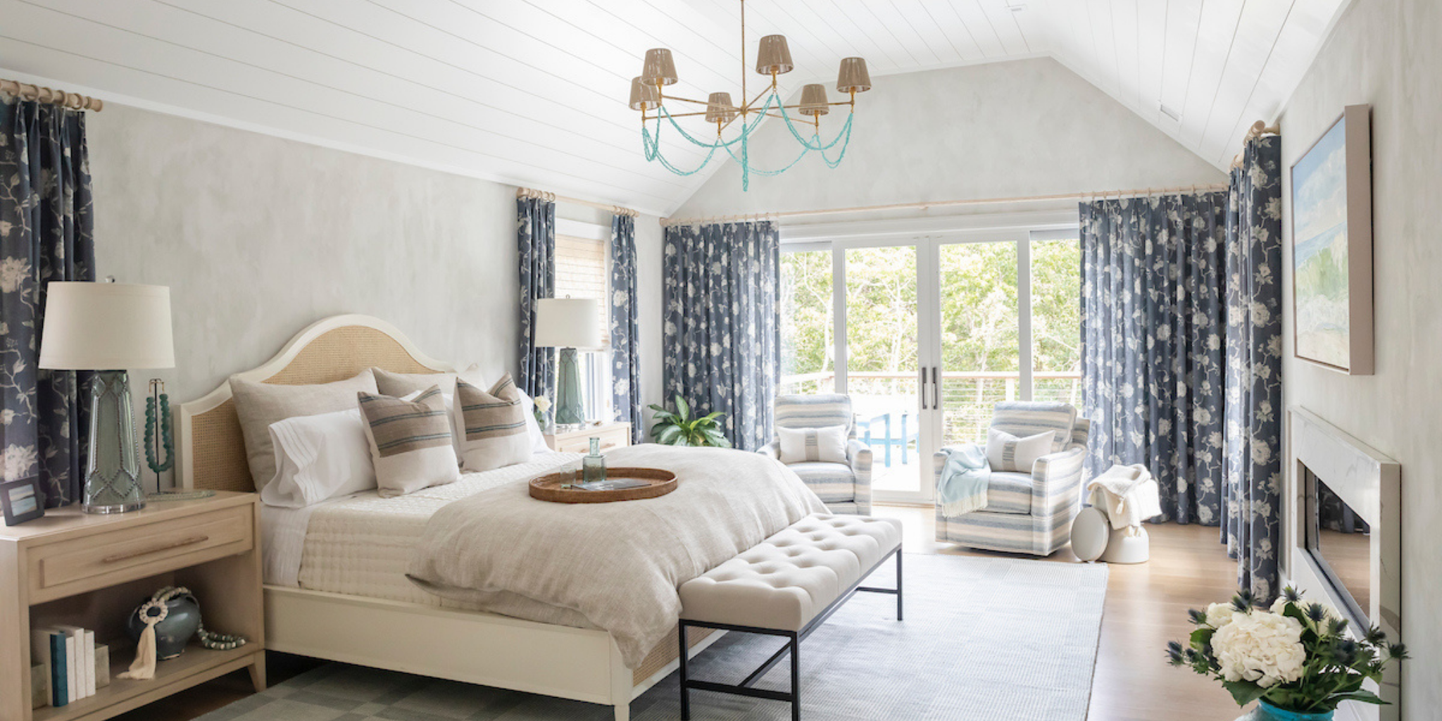 Modern bedroom with a large bed, side tables, and a chandelier.